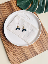 Load image into Gallery viewer, Smooth Black Leather Arch and Tiny Brass Disc Earrings