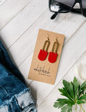 Load image into Gallery viewer, bright red leather statement earrings in a dangly style with brass horseshoe accent
