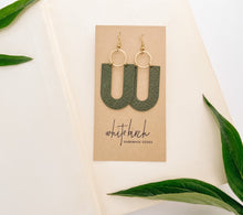 Load image into Gallery viewer, green leather earrings in a u shape with brass accents
